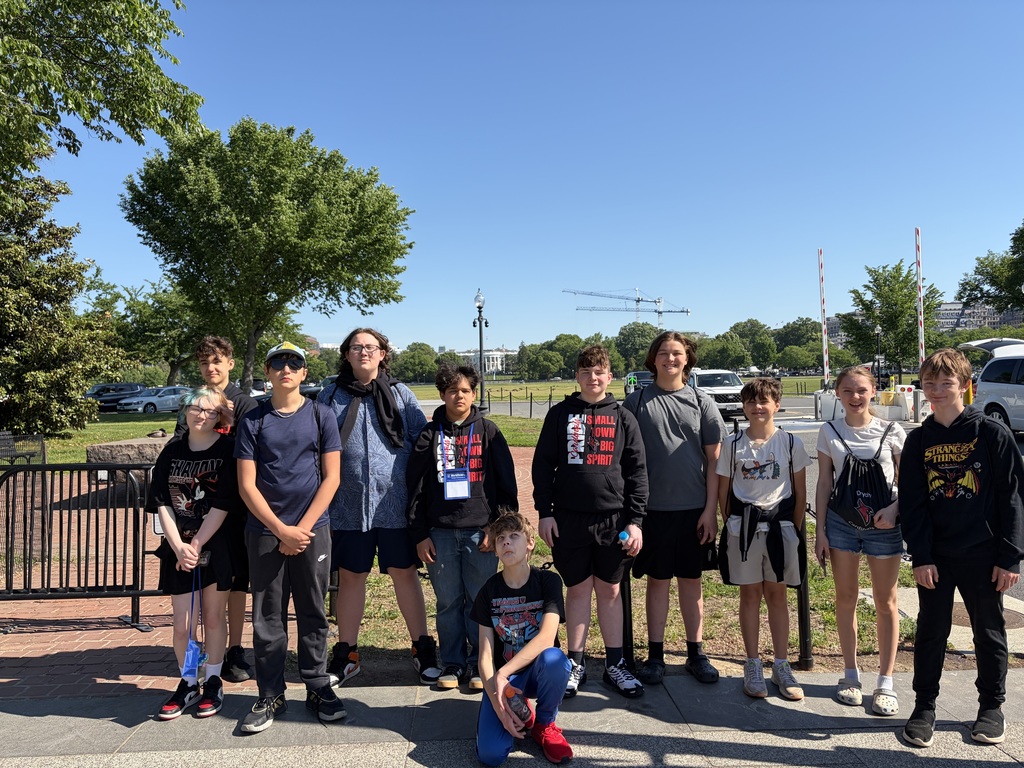 group of students standing by a fence
