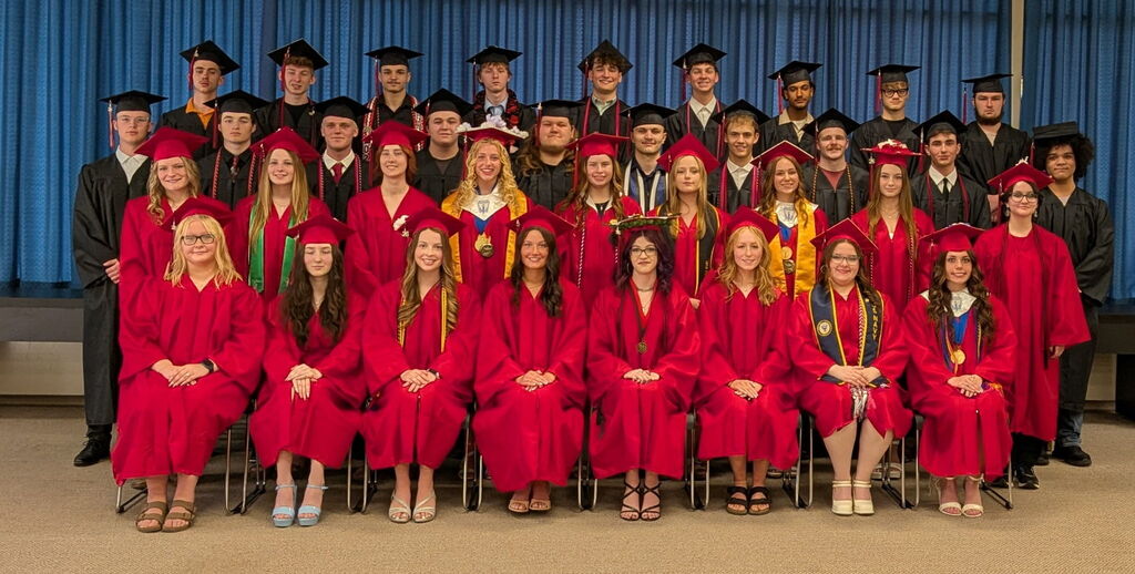 Seated group of high school graduates in caps and gowns