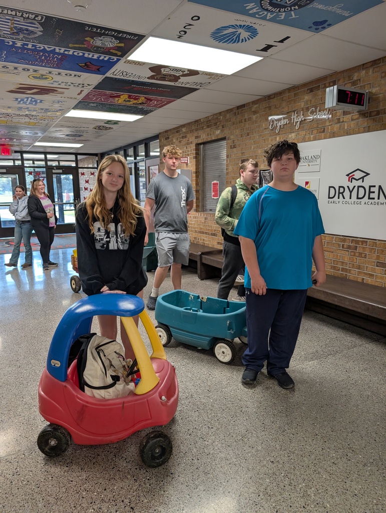 two junior high students standing with kids toys and wagon