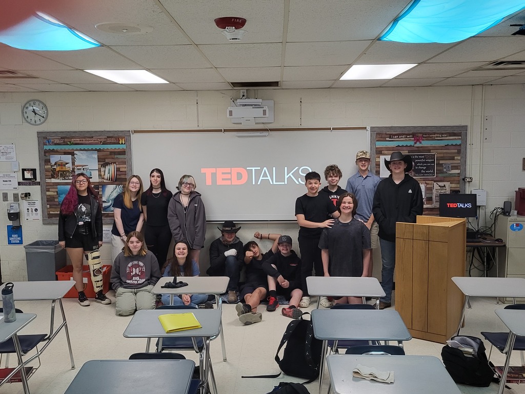 group of 8th graders standing by a big computer screen