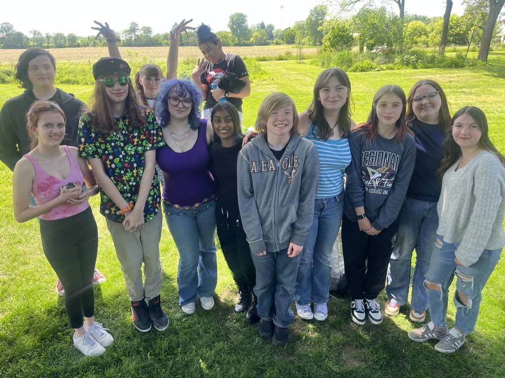 group of high school students standing in a front yard