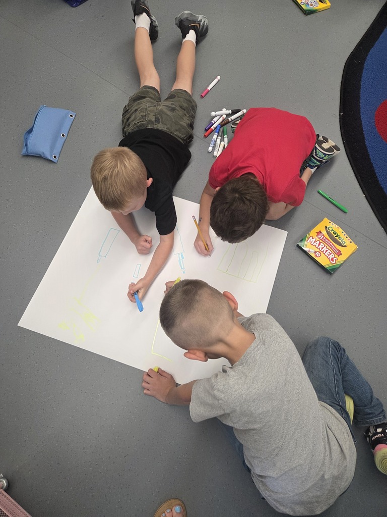 First graders worked in groups to design posters to help students remember how to play safe and have fun on our playground.