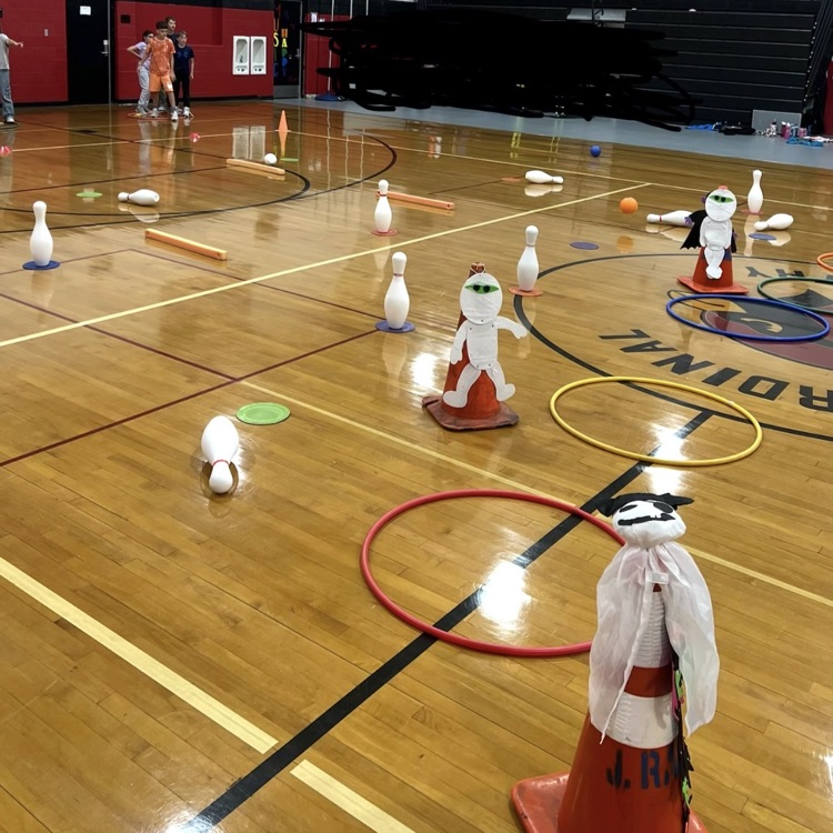Students during PE class are practicing teamwork, good sportsmanship, rolling a ball towards a target, addition and cardio during the activity “trick or treat” bowling.