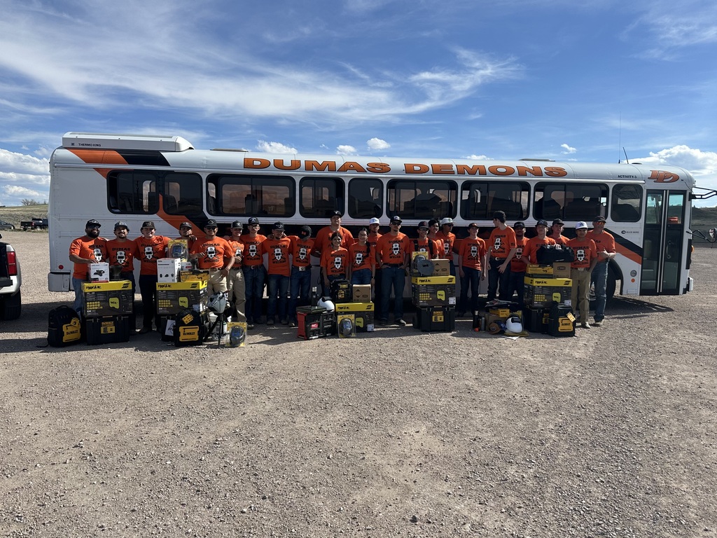 Welding Team with their prizes standing in front of the bus