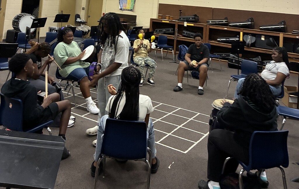 Middle School Student sitting in a circle with drums 4