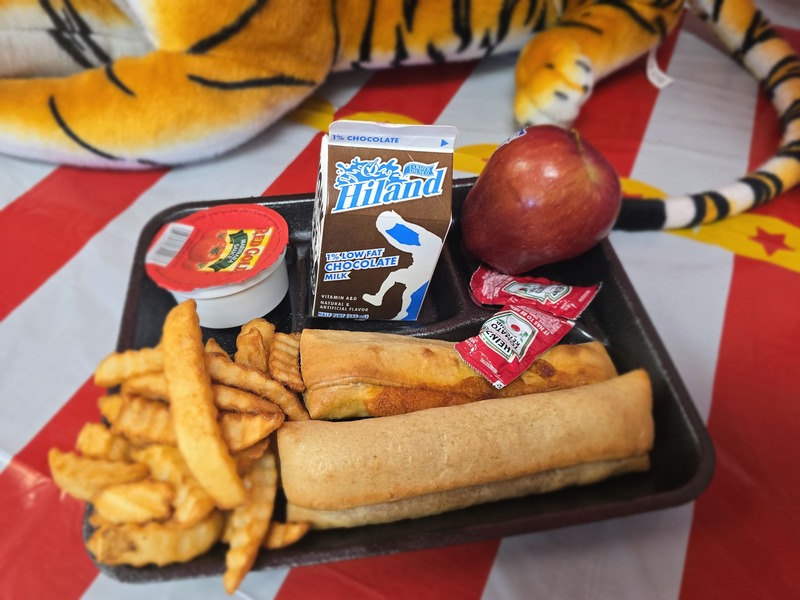 Cafeteria tray with fries and apple with milk