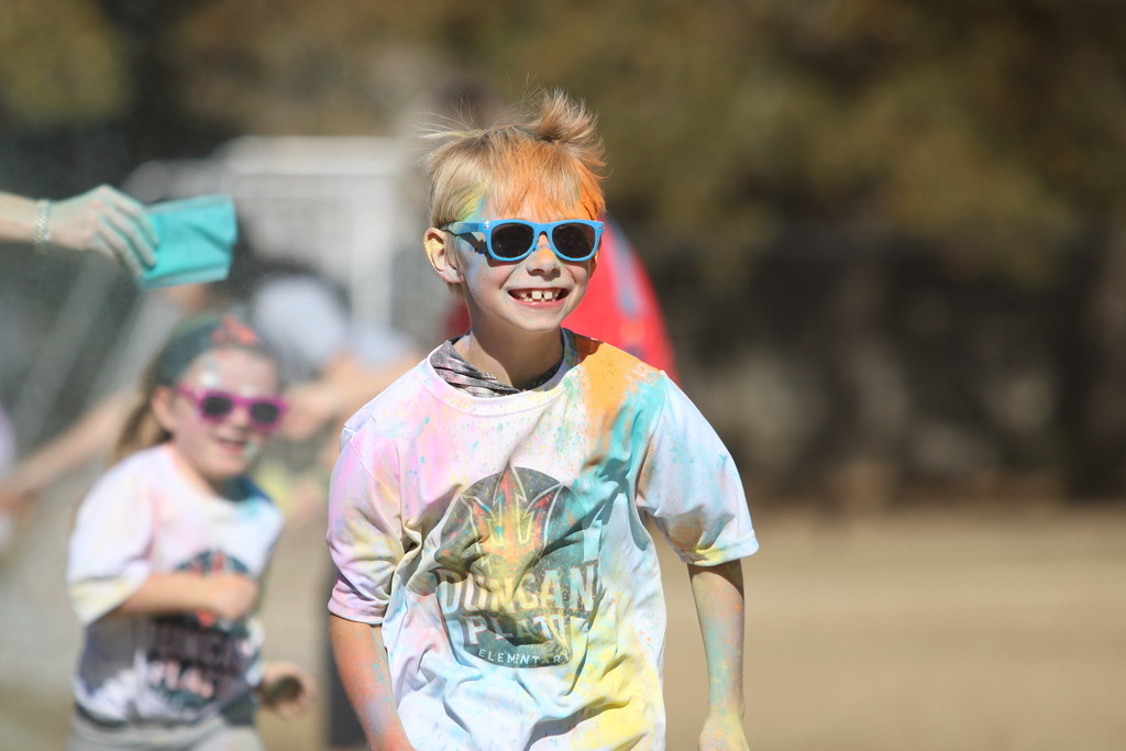 student smiling running during color run 