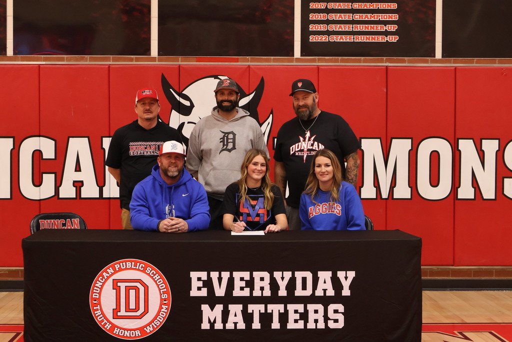 student and family smiling at signing table