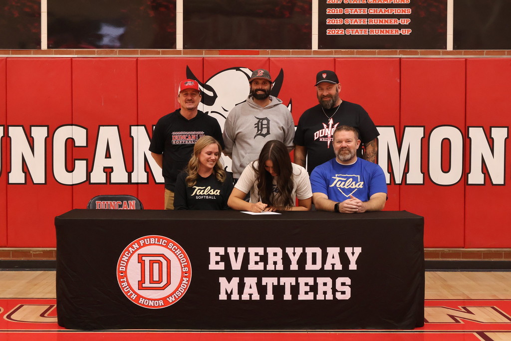 student and family smiling at signing table