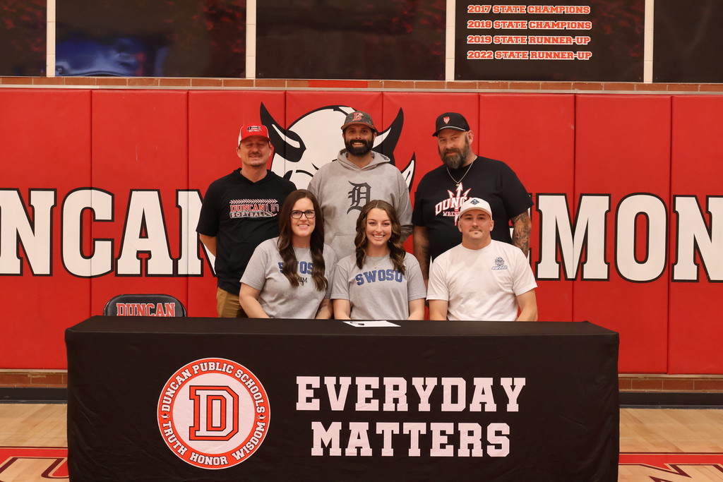 student and family smiling at signing table