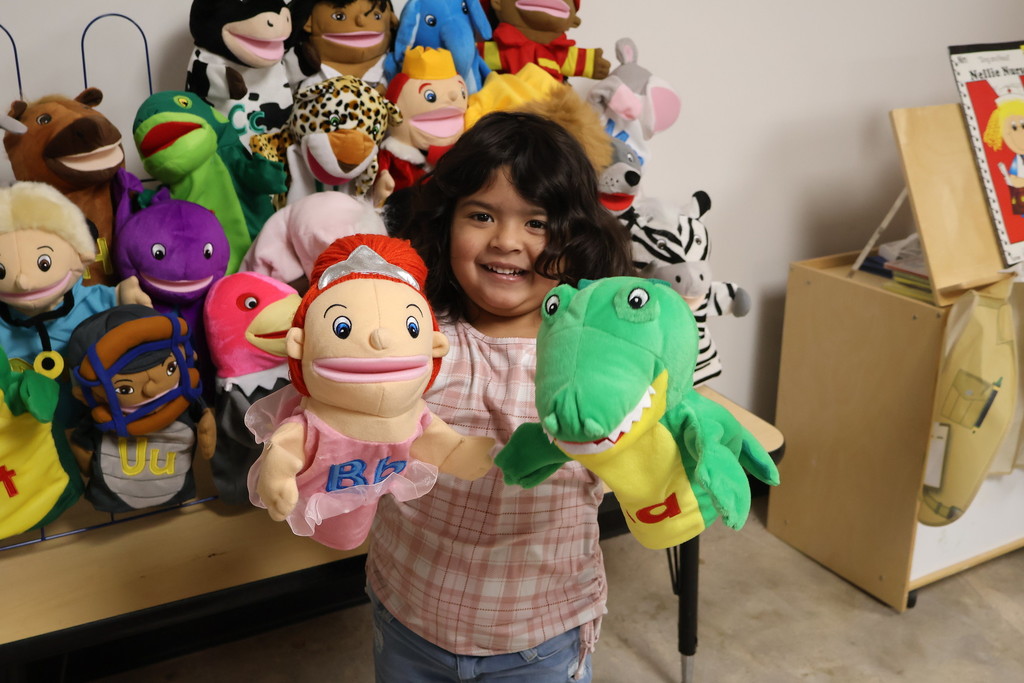 child  holding puppets 