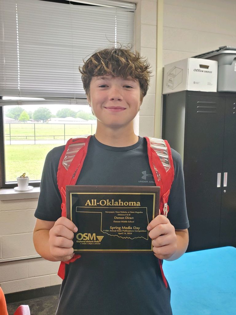 student smiling with award 