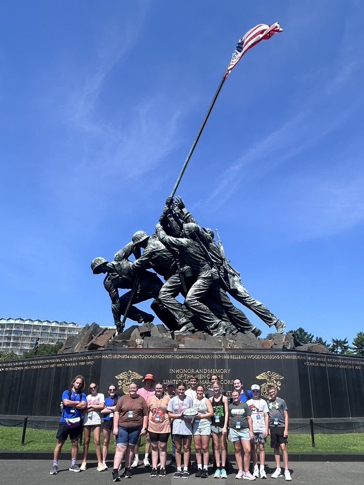 a group of students posing in front of the iconic US Marine Corps memorial in Washington, DC