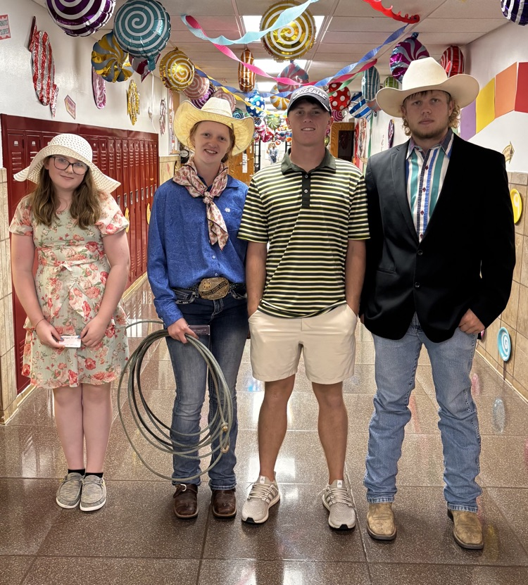 four students stand posing in the hallway