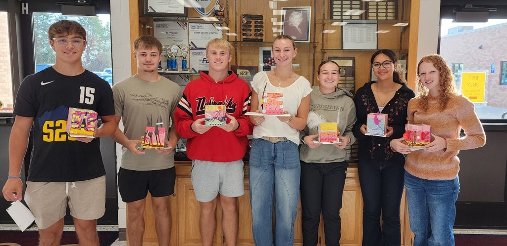 students holding models they made of the integumentary (skin)