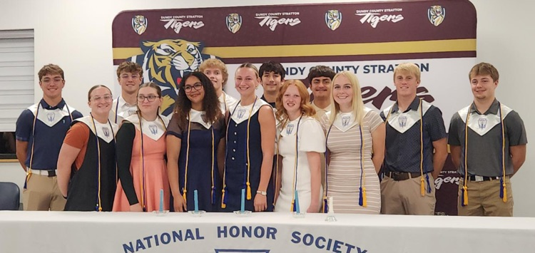 13 senior members stand smiling