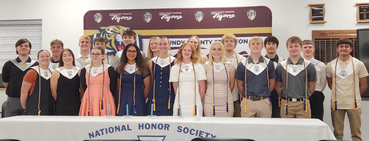 All current members who attended induction pose in between the DCS tiger banner and the ceremony banner