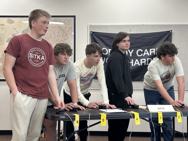 5 gentlemen listen intently to a toss up question and prepare to buzz in