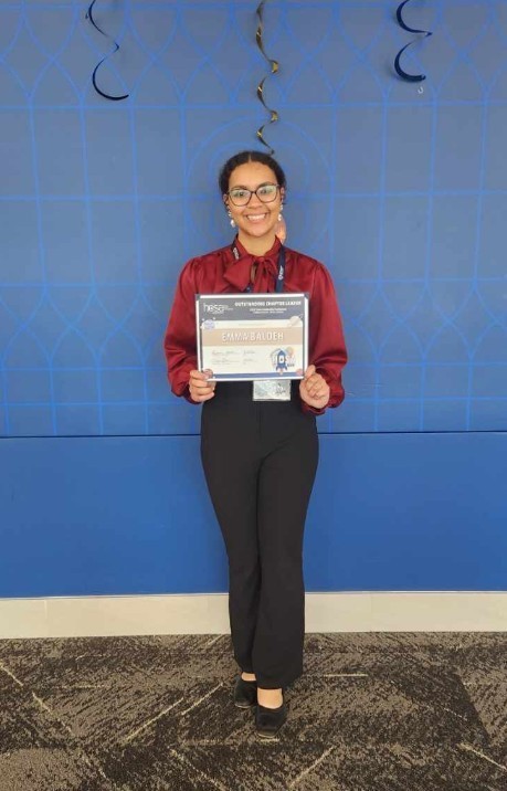 Emma holding her award
