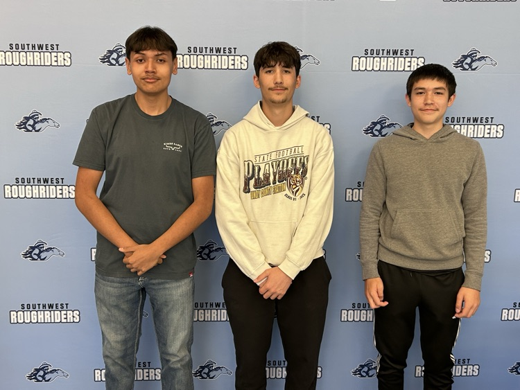 The 3 person team stands in front of the Southwest banner