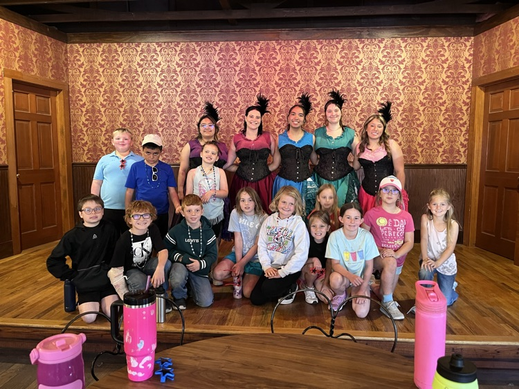 class photo of students with saloon show performers