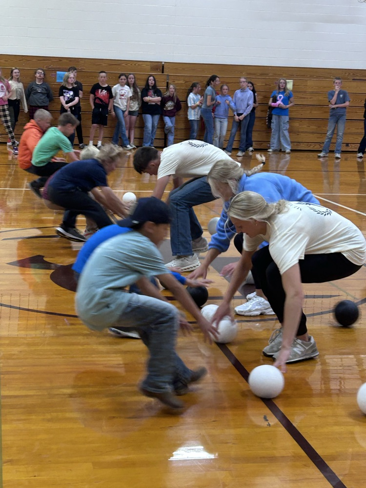Elementary students and high school students try to be the first to grab the dodgeballs from the half court line after sprinting from the baseline