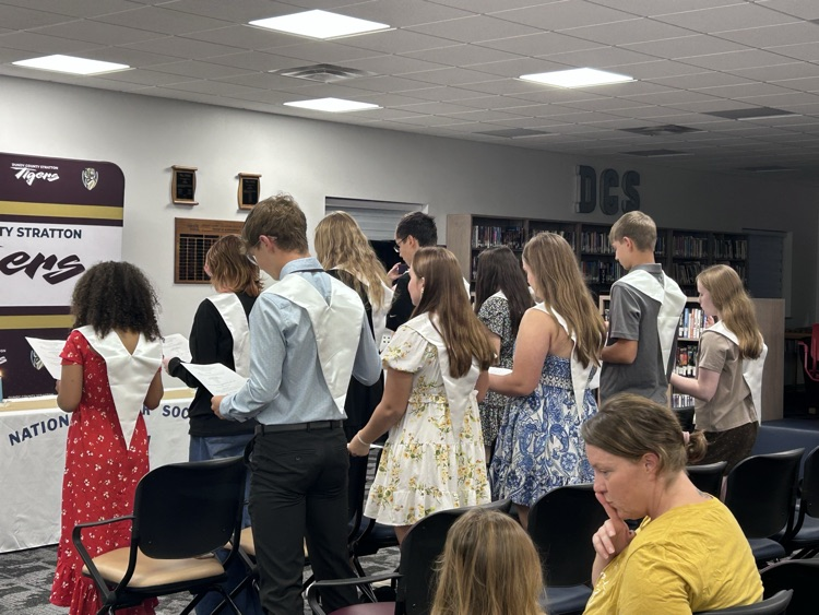 new inductees stand with their right hand raised as they repeat the induction pledge