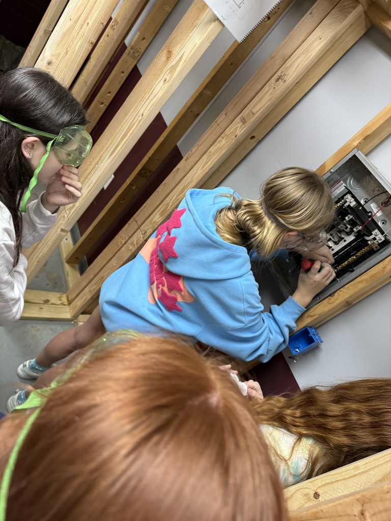 Izzy has just finished showing these students how to connect a circuit breaker to a panel. 
