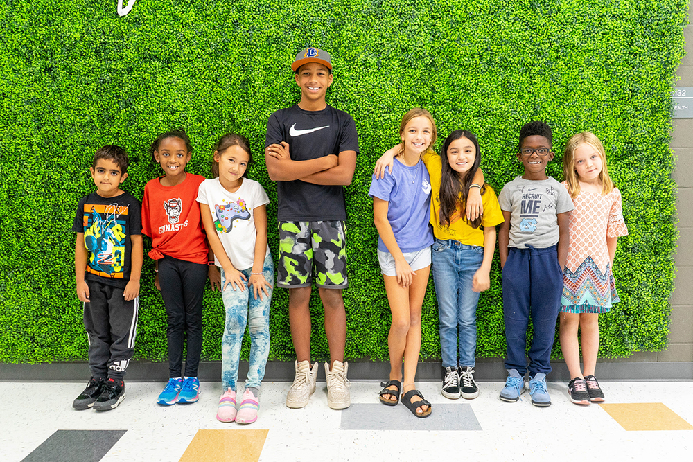 kids standing against green wall