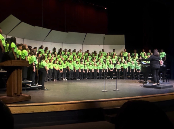 Pearsontown chorus in formation wearing green shirts.