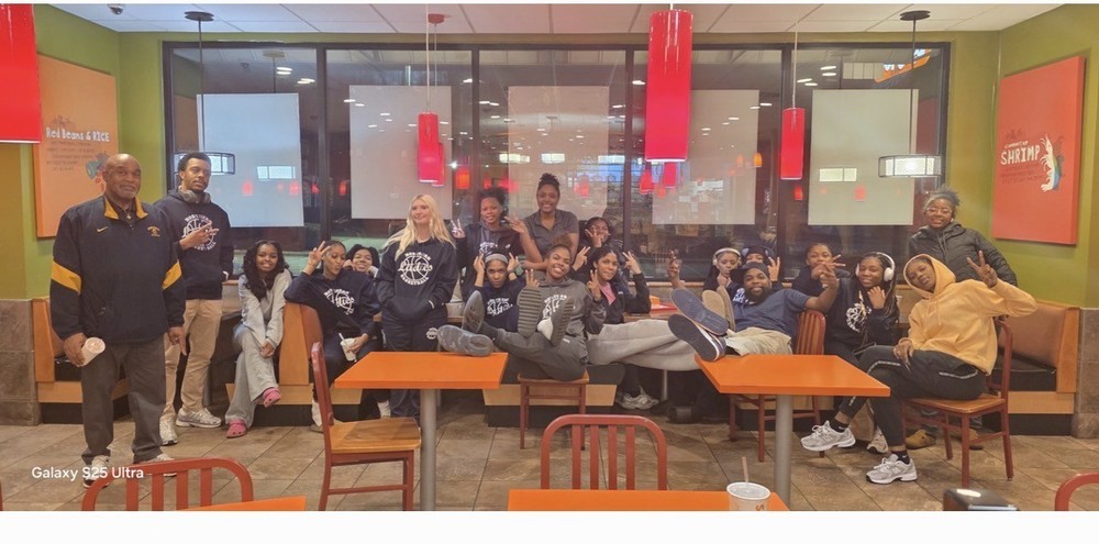 Picture of the women's basketball team relaxing at a restaurant after their Elite 8 game.