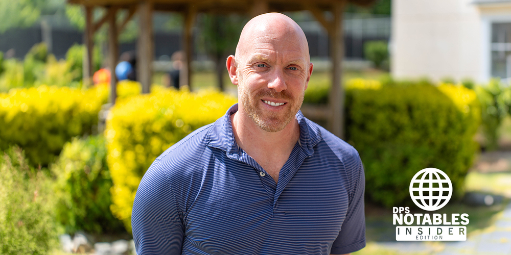 A smiling man in a blue shirt stands outside, surrounded by greenery and yellow bushes. "DPS Notables Insider Edition" logo is in the bottom right corner.