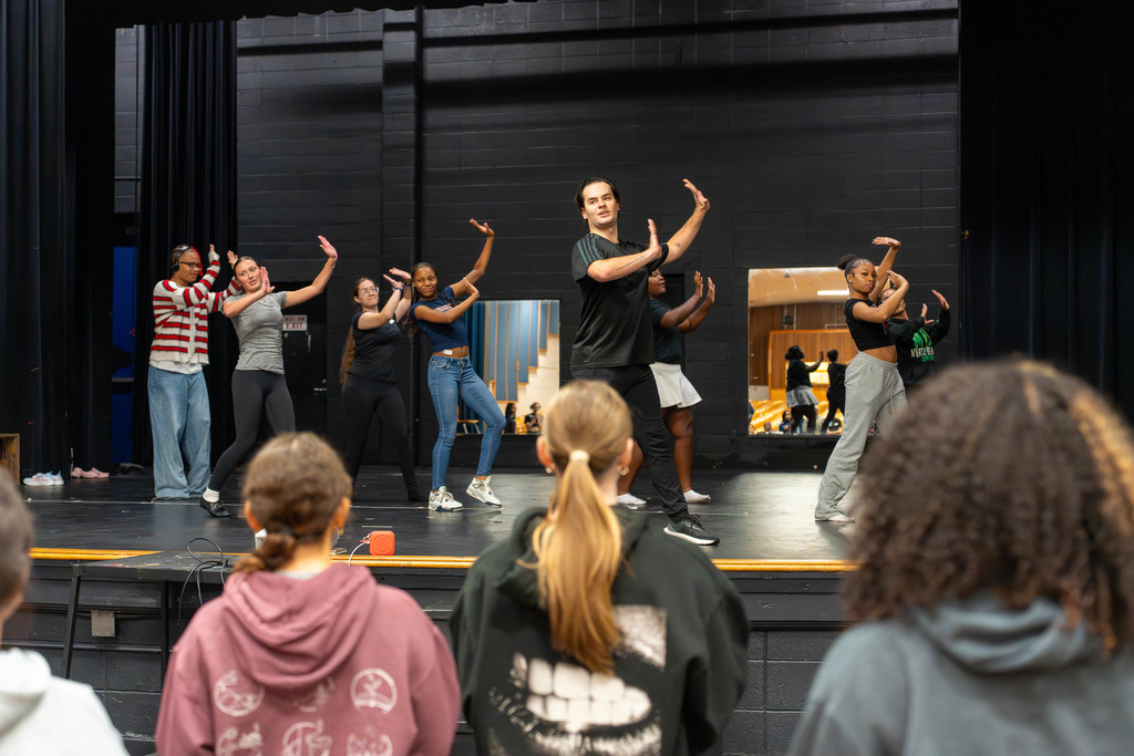 Students dancing on a stage with an instructor