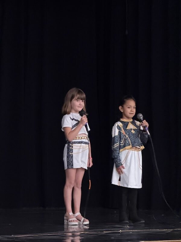 Two girls singing on stage