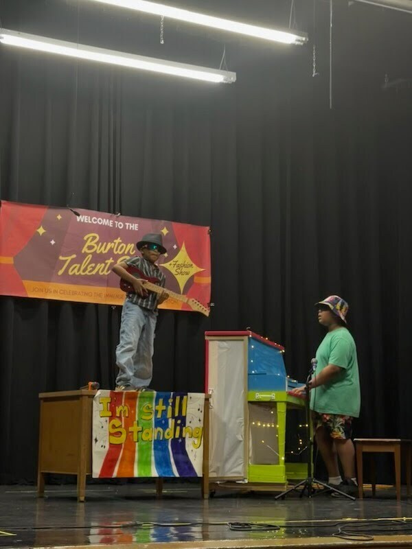 Two students boys performing with a piano and a guitar