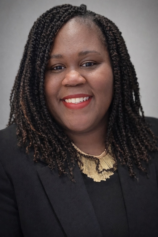 Dr. Cunningham in black blouse and black blazer, smiling