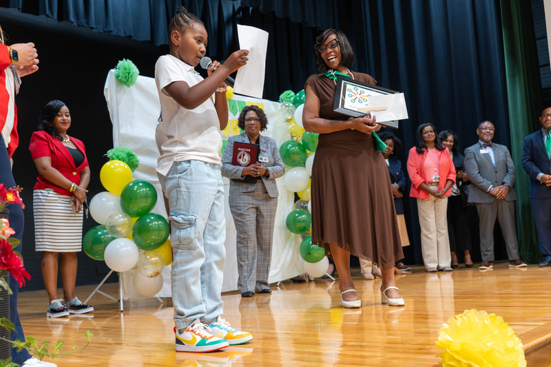 Dr. Alford smiling as student reads their letter to her