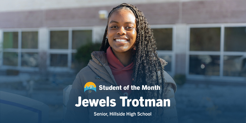 Smiling young woman with long braids wearing a jacket, standing outside a building. Text reads "Student of the Month, Jewels Trotman, Senior, Hillside High School."