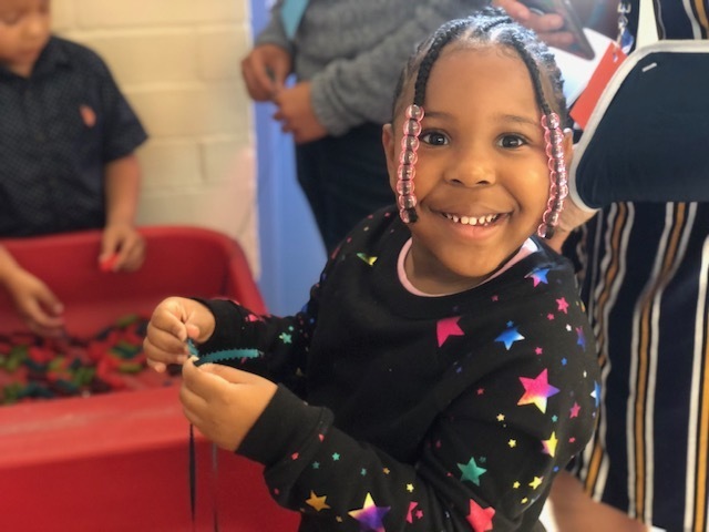 Child, smiling, holding bracelets