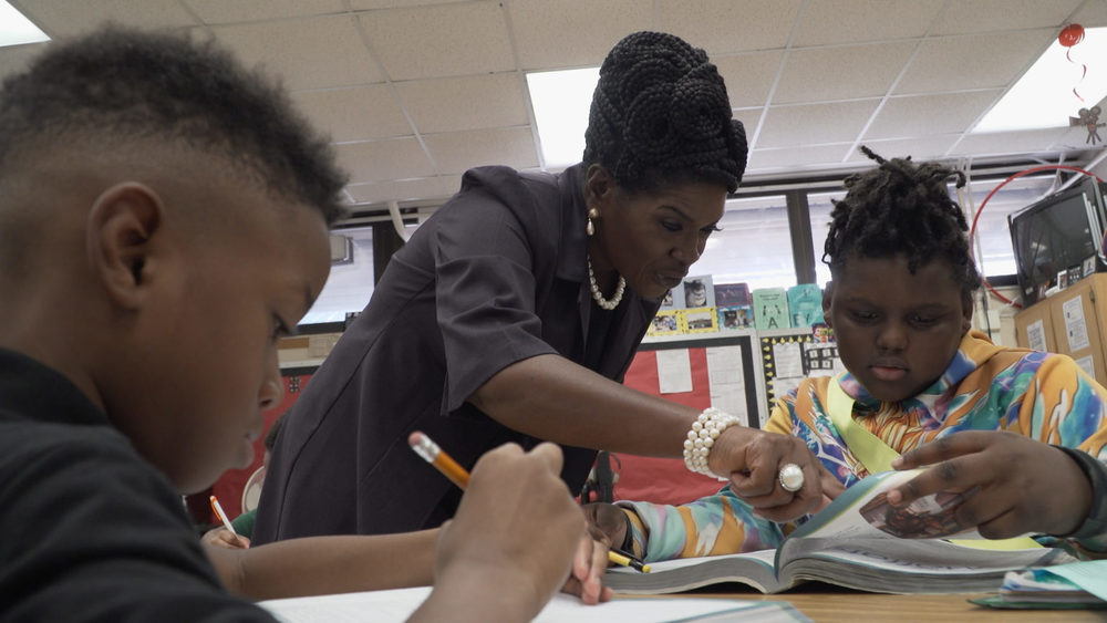 Teacher showing student something in a book