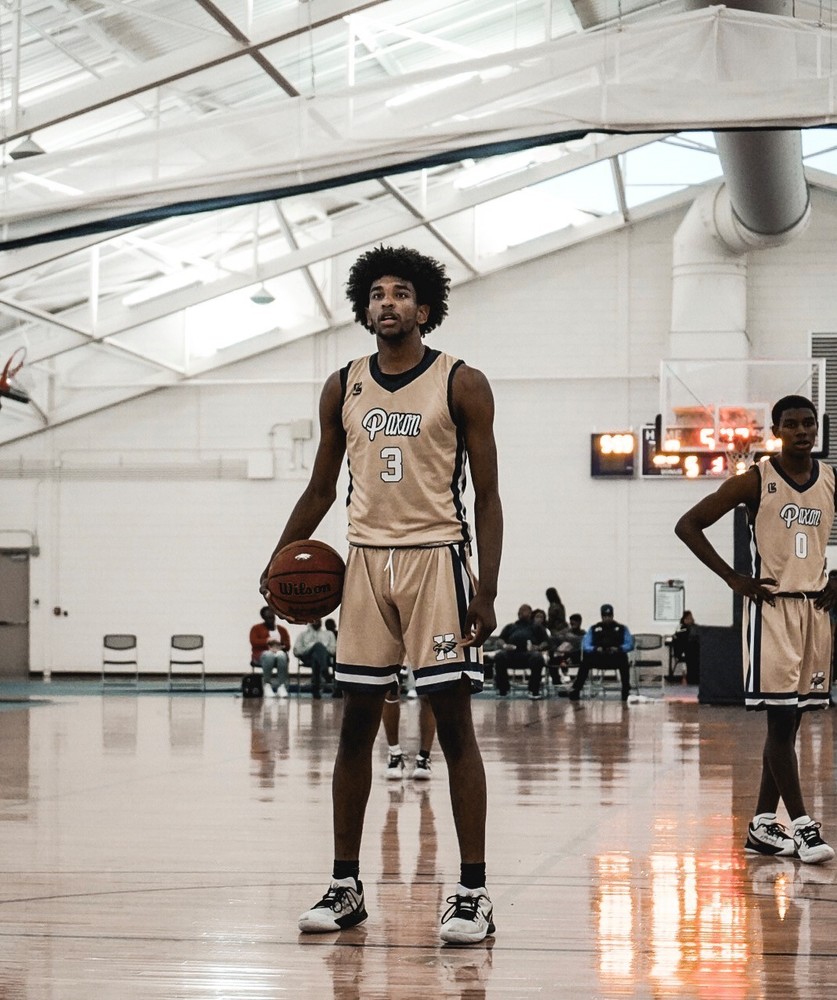 Basketball player, standing on court with basketball in hand