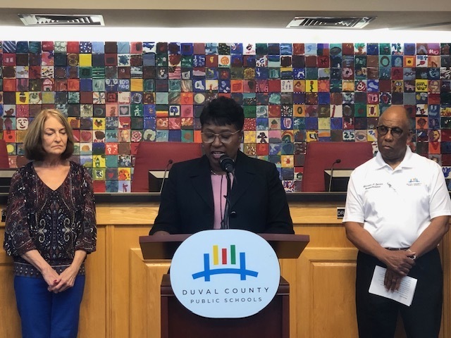 Teacher giving speech at podium.