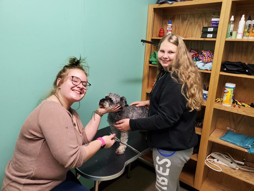 Students pose with a dog as they are learning about animal care  