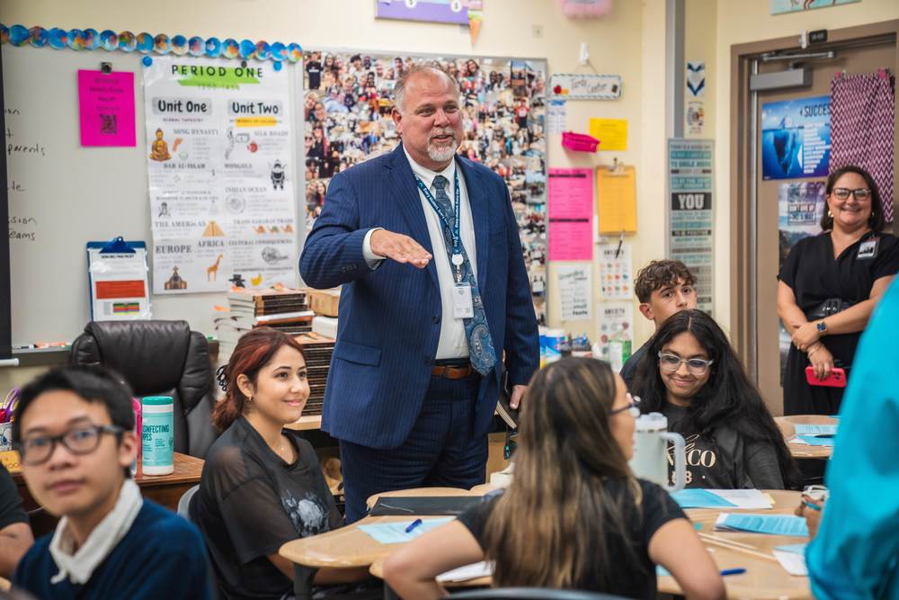 Dr. Bernier addresses a group of smiling students.