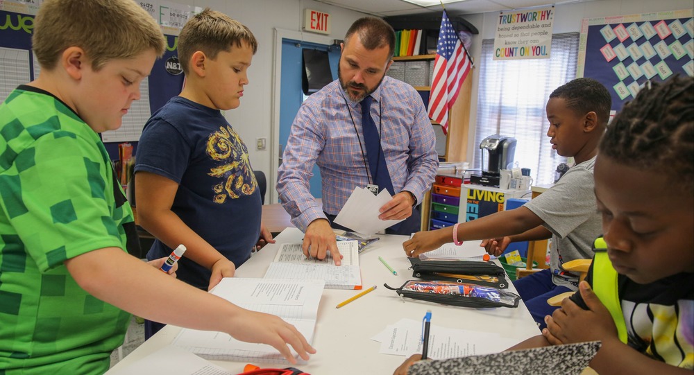 Teacher instructing four students