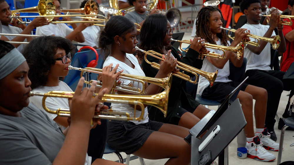 The trumpet section of Andrew Jackson High School Band watches intently during a full band rehearsal.