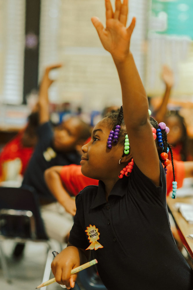 Student raising hand in class.