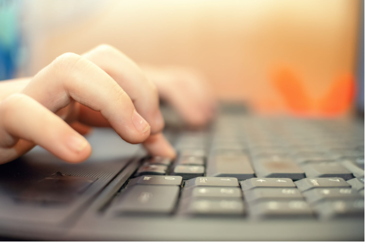 Image of a student's hands typing on a keyboard