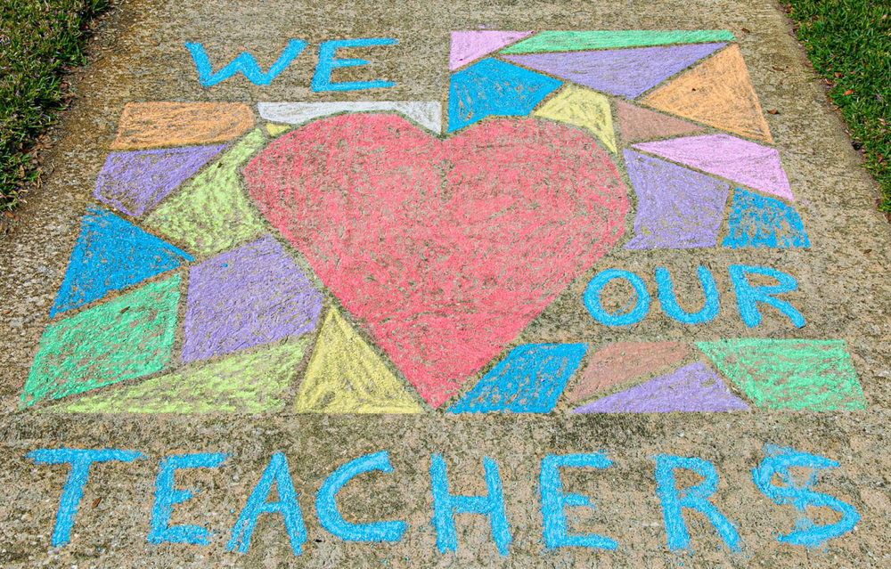 Sidewalk with writing that says "we our teachers."