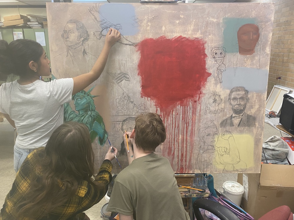 Students painting a canvas